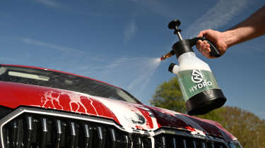 Auto Express products editor Tom Barnard washing a Skoda Superb with a Hydro V2 spray bottle